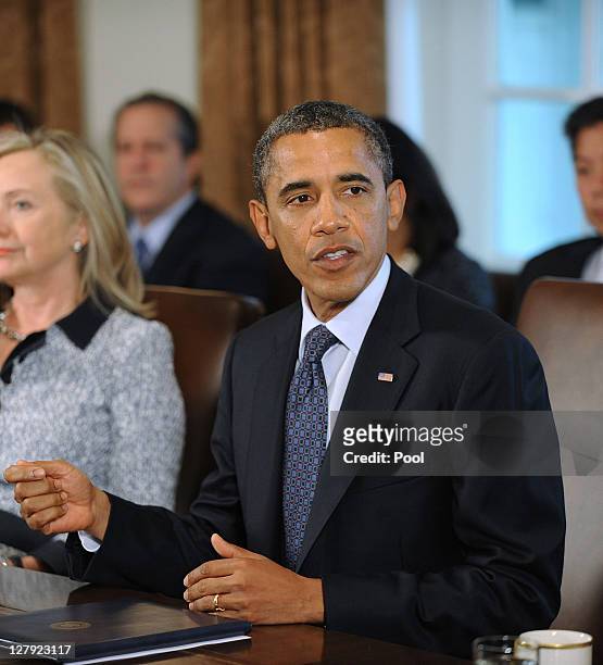 President Barack Obama speaks during a Cabinet meeting as U.S. Secretary of State Hillary Clinton listens in the Cabinet Room October 3, 2011 at the...