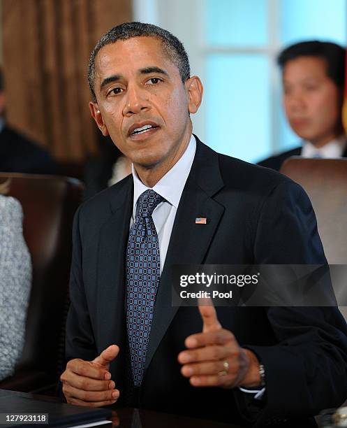 President Barack Obama speaks during a Cabinet meeting as U.S. Secretary of State Hillary Clinton listens in the Cabinet Room October 3, 2011 at the...