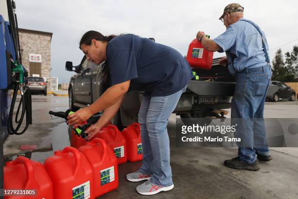 Local residents place unfilled gas cans back in their truck after discovering there was no regular gasoline left at the station as they prepare for...