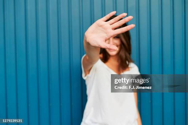 portrait of woman covering her face with her hand - stop sign stock pictures, royalty-free photos & images