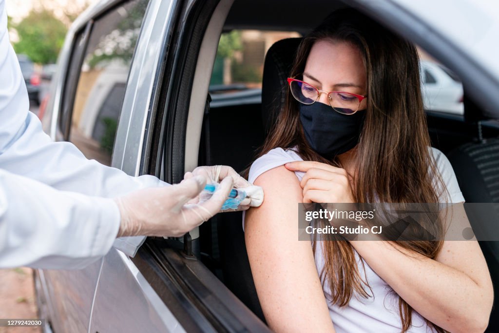 ドライブスルー予防接種を行う看護師