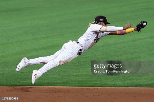 Fernando Tatis Jr. #23 of the San Diego Padres dives to cut off a ball hit by Corey Seager of the Los Angeles Dodgers during the third inning in Game...