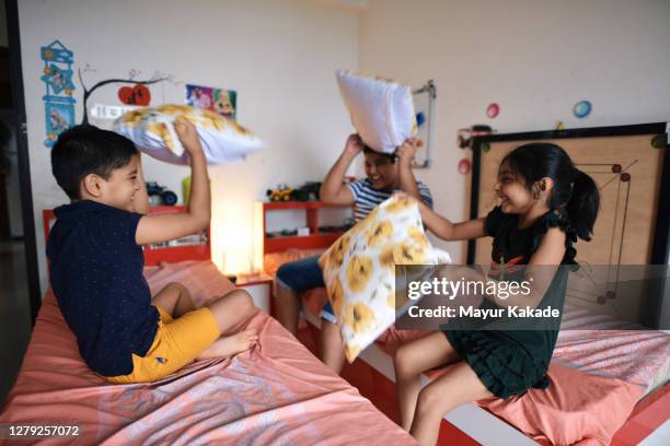 siblings playing pillow fight - sibling stock pictures, royalty-free photos & images