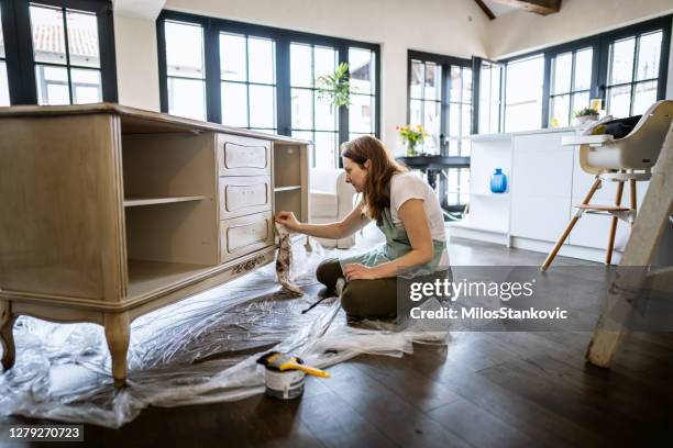 jonge vrouw die een oud meubilair herstelt en thuis geniet - restaureren stockfoto's en -beelden