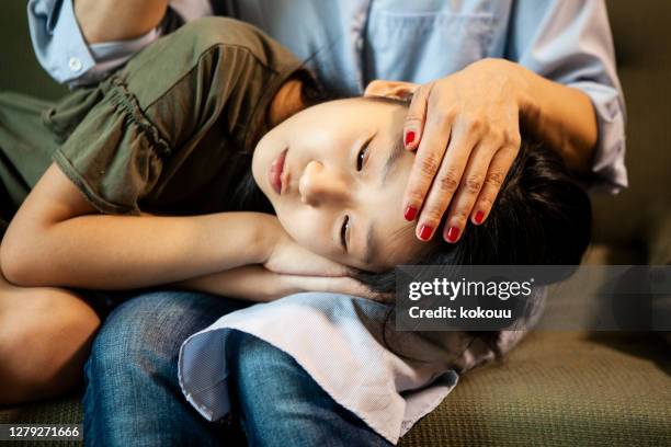 mother measuring the temperature of her sleeping daughter - teenager headache stock pictures, royalty-free photos & images