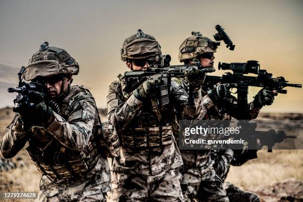 soldati dell'esercito che combattono la scena in guerra con sfondo al tramonto - esercito foto e immagini stock