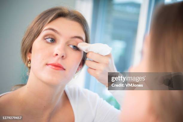 junge frau wiping make-up aus gesicht im badezimmer - wet wipe stock-fotos und bilder