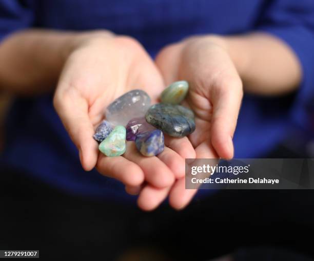 close-up of gemstones in the hands of a woman - edelstein stock-fotos und bilder