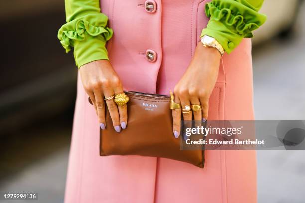 Gabriella Berdugo wears a total look Prada, a green ruffle blouse with long sleeves, a pink pencil midi skirt with pockets, a brown leather pouch /...
