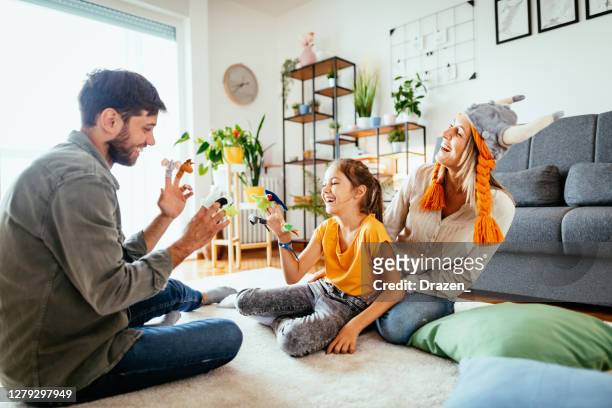 family at home playing with daughter - having theater performance with finger puppets - puppeteer stock pictures, royalty-free photos & images