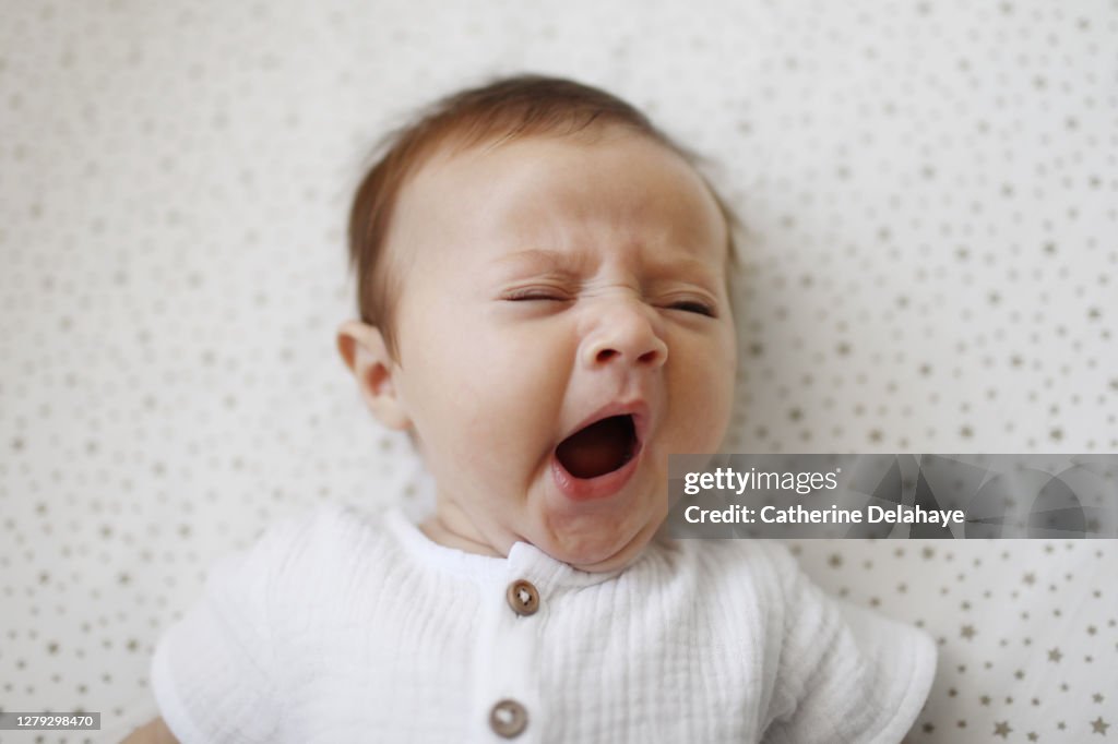 A 4 month old baby girl yawning