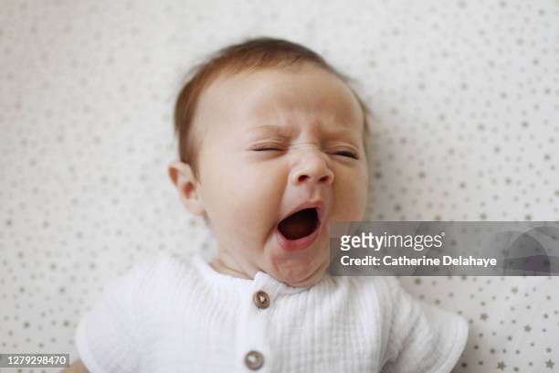 a 4 month old baby girl yawning - bebé foto e immagini stock