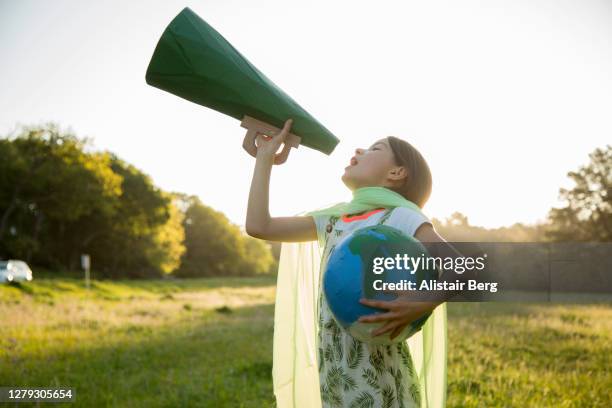 female eco-warrior shouting into a megaphone - superhero girl stock pictures, royalty-free photos & images