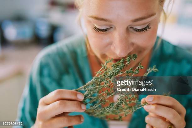 woman smells fresh herbs - fragrance stock pictures, royalty-free photos & images