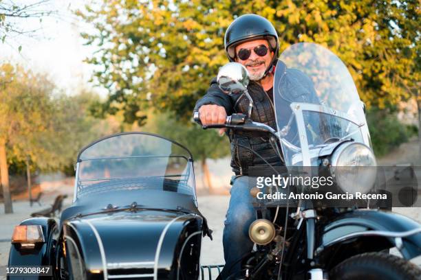mature man biker poses driving his sidecar - motorbike sidecar stock pictures, royalty-free photos & images