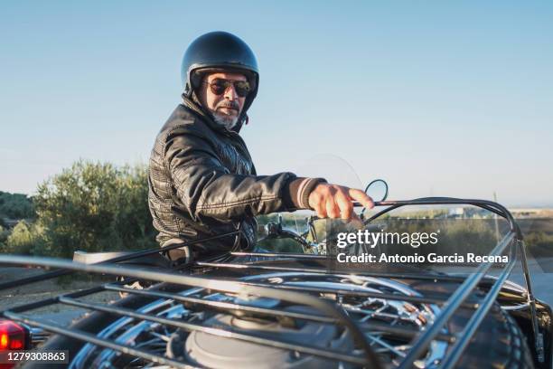 mature man on sidecar bike looking serious at camera - motorradfahrer stock-fotos und bilder