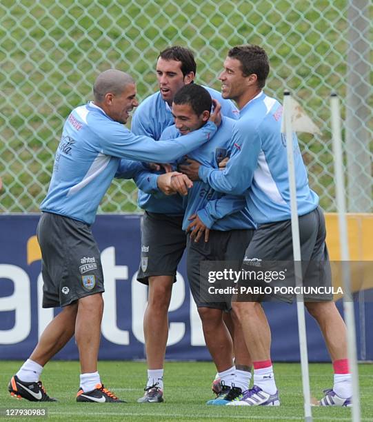Uruguayan footballer Walter Gargano is welcomed by teammates Maximiliano Pereira Diego Godin and Diego Scotti during a training session of the...