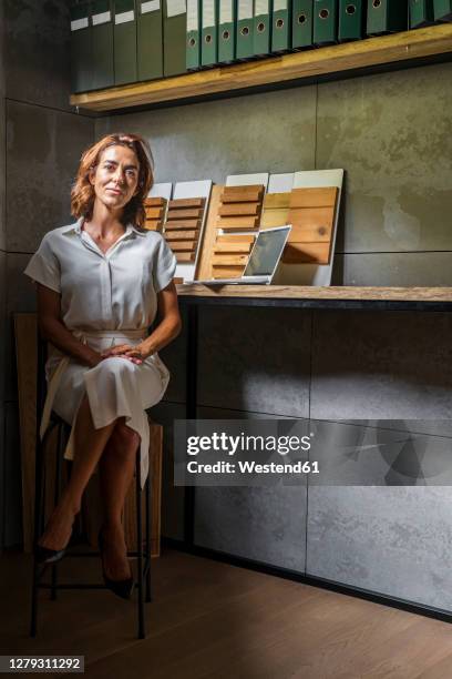 businesswoman with wood tiles sitting by desk at office - wood worker posing ストックフォトと画像