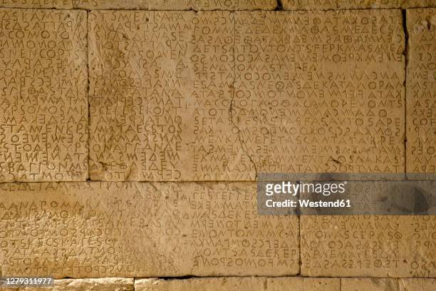 alphabet carved on stonewall at odeon of gortyn, crete, greece - ancient greek alphabet stock pictures, royalty-free photos & images