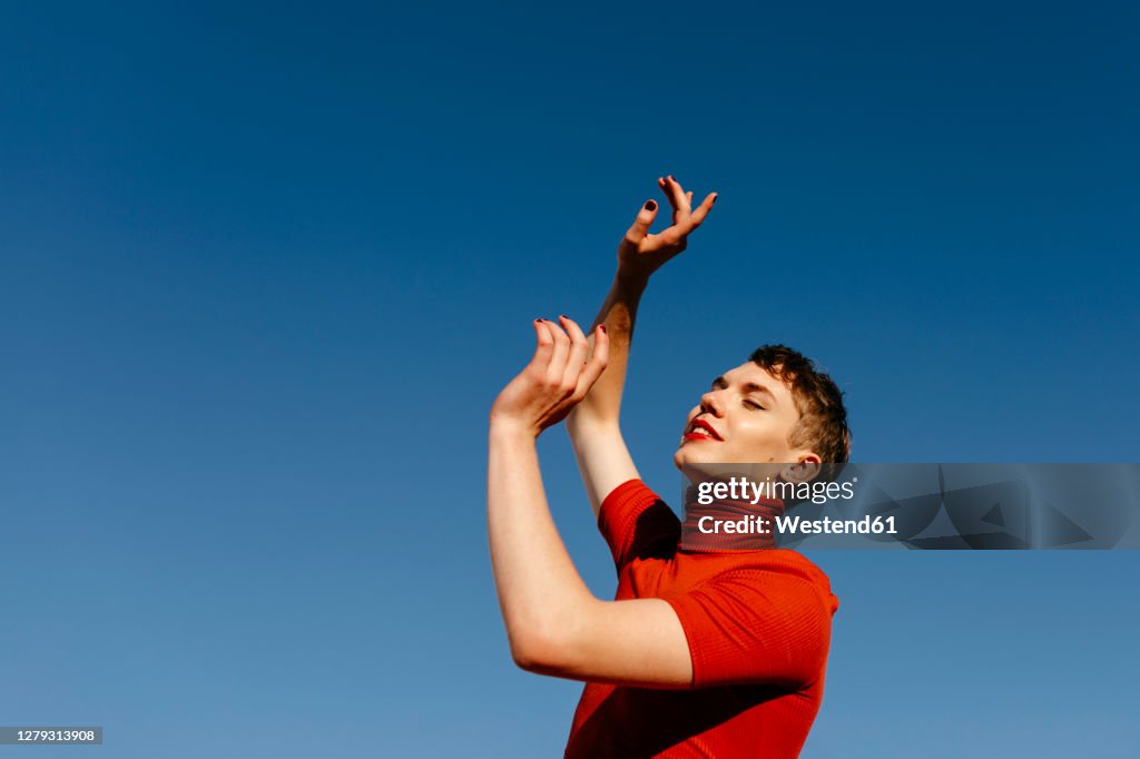 Gender fluid person dancing against clear sky on sunny day