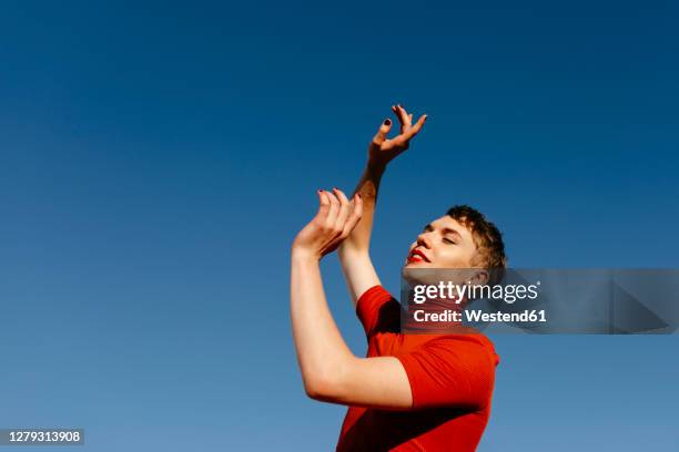 gender fluid person dancing against clear sky on sunny day - men wearing dresses stock-fotos und bilder