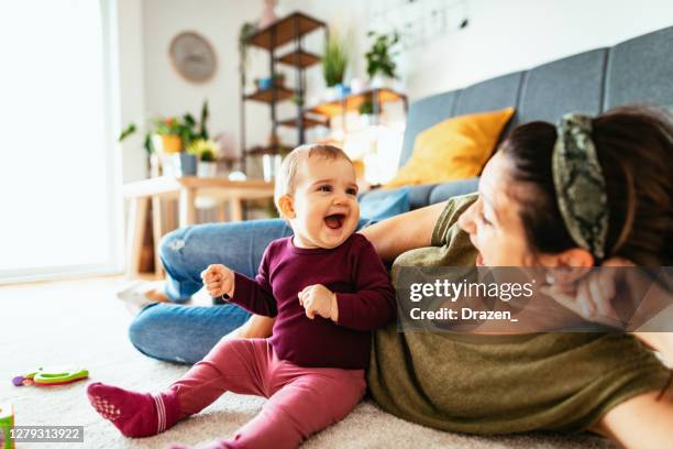 mother playing with seven moth old baby girl at home - quarantine fun stock pictures, royalty-free photos & images