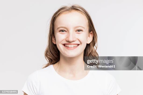 close-up of cute smiling girl against white background - girl white background stock pictures, royalty-free photos & images