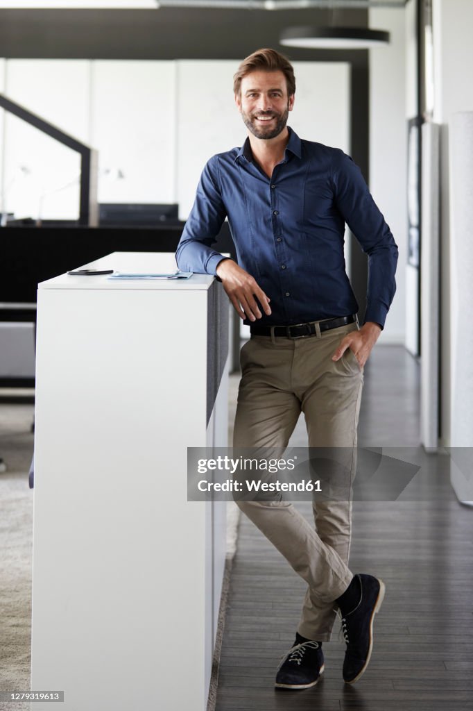 Businessman smiling while standing at office