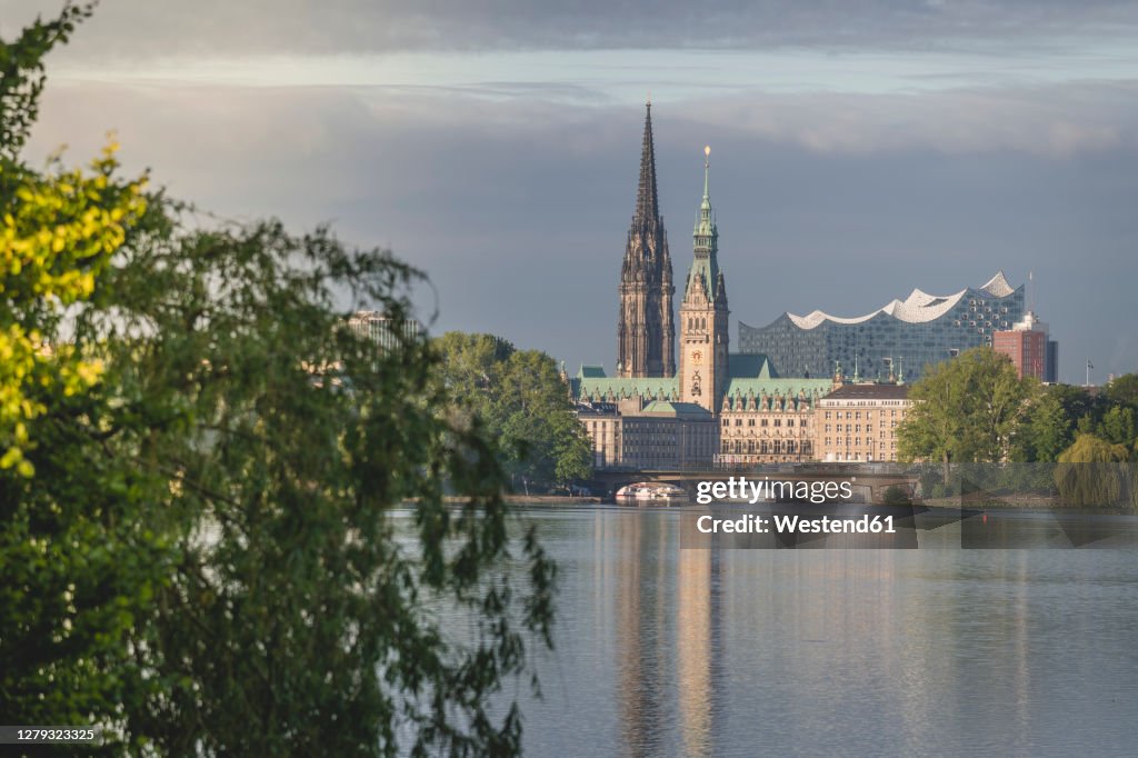 Germany, Hamburg, Town hall, Church of St. Nicholas and Elbphilharmonie seen across Outer Alster Lake