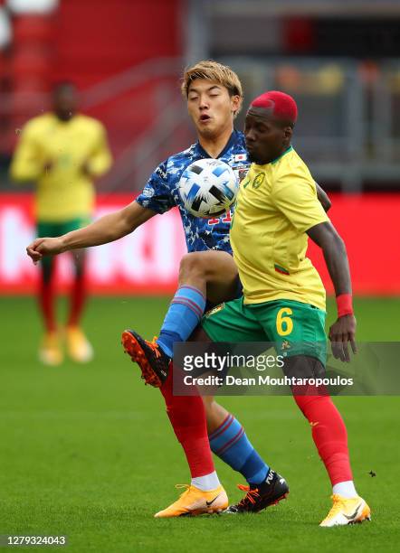 Ritsu Doan of Japan and Ambroise Oyongo of Cameroon battle for the ball during the international friendly match between Japan and Cameroon at Stadion...