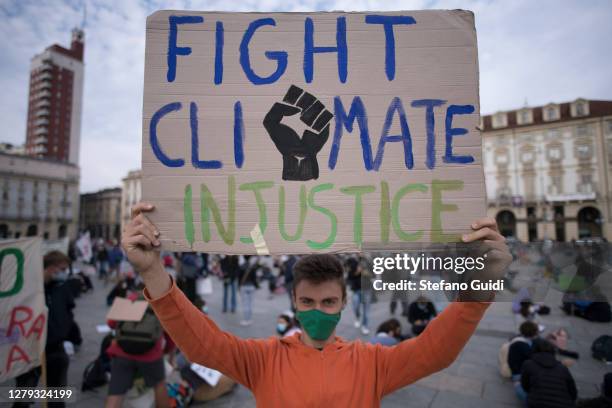 Boy wearing a protective mask holds a sign during a protest as part of the Fridays for Future movement to call for action against climate change on...