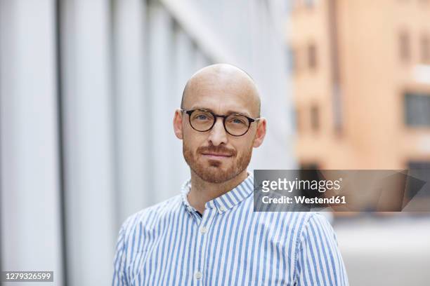 confident mid adult man wearing striped shirt while standing on street - erwachsener über 30 stock-fotos und bilder