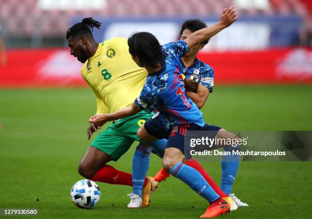 Andre-Frank Zambo Anguissa of Cameroon holds off Gaku Shibasaki and Takumi Minamino of Japan during the international friendly match between Japan...