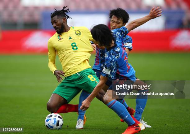 Andre-Frank Zambo Anguissa of Cameroon holds off Gaku Shibasaki and Takumi Minamino of Japan during the international friendly match between Japan...