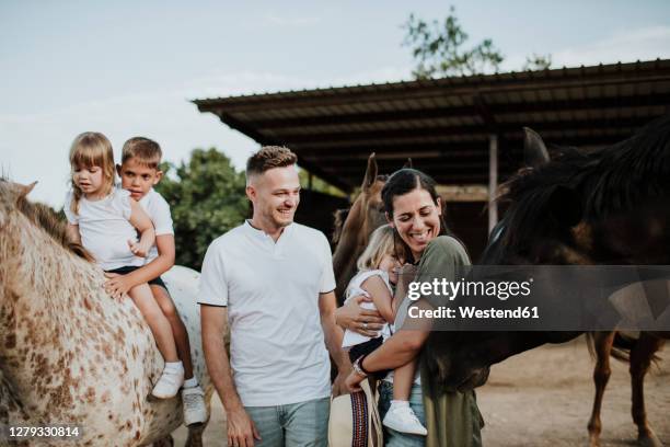 family enjoying with horses in barn - family five people stock pictures, royalty-free photos & images