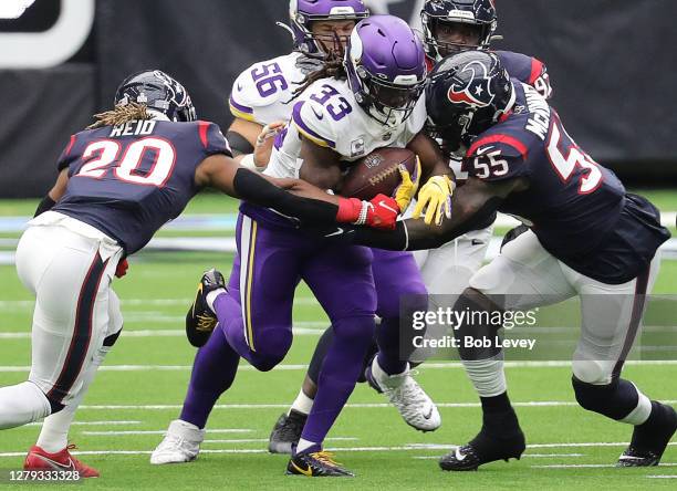 Dalvin Cook of the Minnesota Vikings is tackled by Justin Reid of the Houston Texans and Benardrick McKinney at NRG Stadium on October 04, 2020 in...