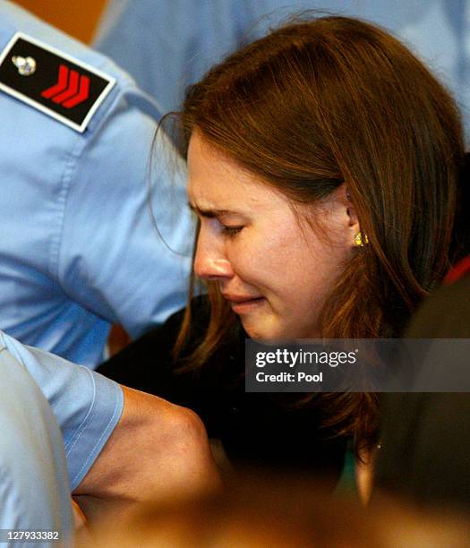 Amanda Knox breaks down in tears as she is taken away after hearing the verdict that overturns her conviction and acquits her of murdering her...