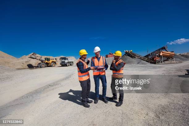open-pit mine team discussing plans - mining natural resources stock pictures, royalty-free photos & images