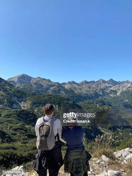 couple enjoying active lifestyles, hiking on mount vogel on sunny autumn day - hochplateau stock-fotos und bilder