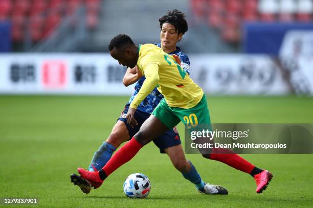 Fabrice Olinga of Cameroon holds off Genki Haraguchi of Japan during the international friendly match between Japan and Cameroon at Stadion...