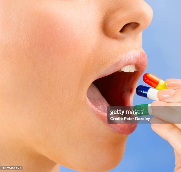 close up of woman's mouth with capsules - ibuprofen stock pictures, royalty-free photos & images