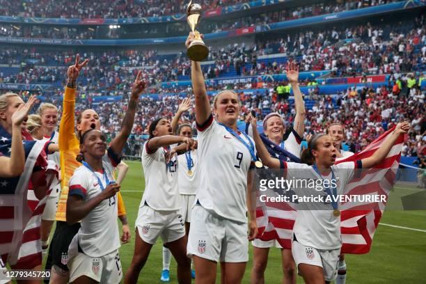 Lindsey Horan au milieu de l'équipe féminine de football américaine brandit le trophée après le match de la finale de la coupe du monde remportée...