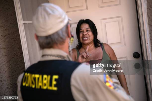 Tenant speaks with a Maricopa County constable who arrived with an eviction order on October 7, 2020 in Phoenix, Arizona. The tenant was able to...