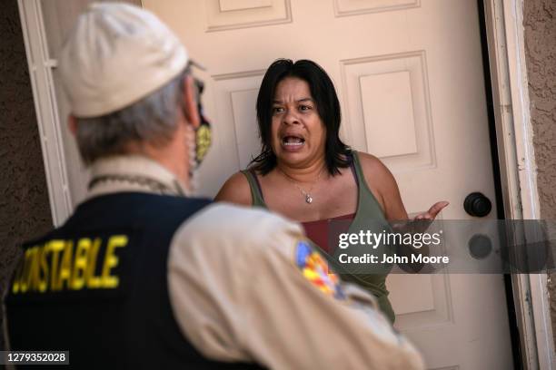 Tenant speaks with a Maricopa County constable who arrived with an eviction order on October 7, 2020 in Phoenix, Arizona. The tenant was able to...