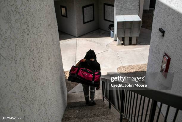 An apartment resident carries out a bag of clothing while being evicted for non-payment of rent on October 5, 2020 in Phoenix, Arizona. Thousands of...