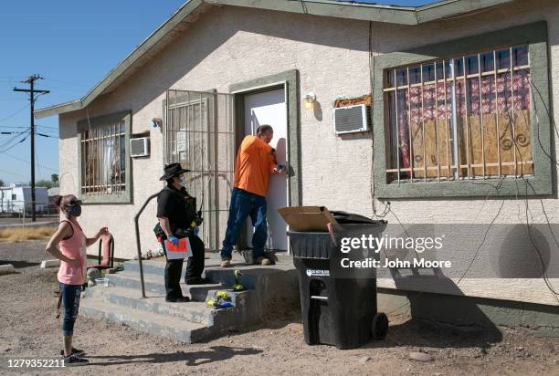 Maintenance man breaks the lock of a house as Maricopa County constable Darlene Martinez serves an eviction order on October 1, 2020 in Phoenix,...