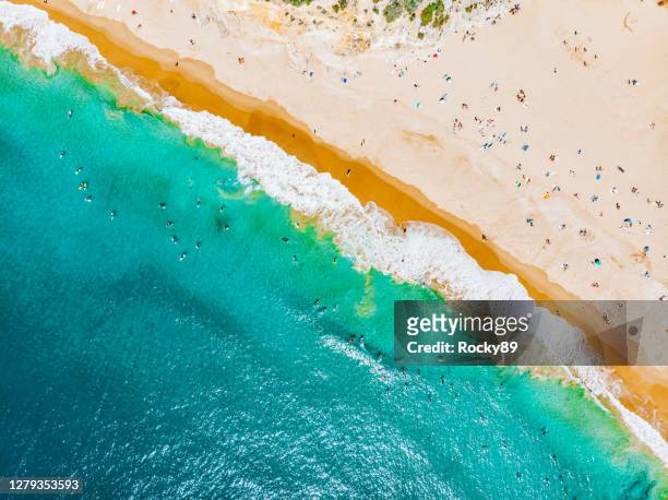 surfer and sunbather at praia do beliche as viewed from the drone, near sagres, portugal - portugal coast stock pictures, royalty-free photos & images