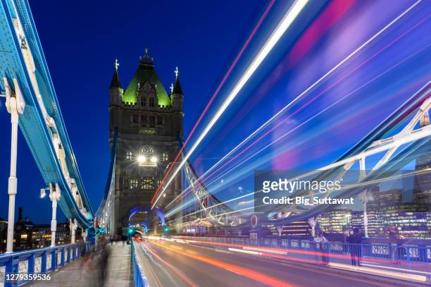 lange blootstelling schot van de tower bridge met een iconische rode bus van londen. - ride london stockfoto's en -beelden