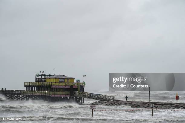 Man stands on the 61st Street Fishing Pier at Galveston Beach as the outer bands of Hurricane Delta pass through on October 09, 2020 in Galveston,...