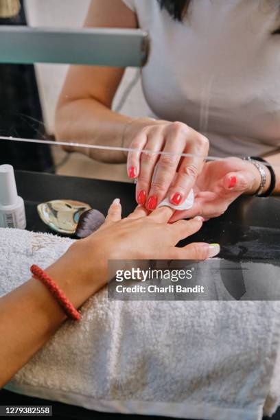 beautician cleaning and polishing fingernails while doing manicure - acrylic nails stock pictures, royalty-free photos & images